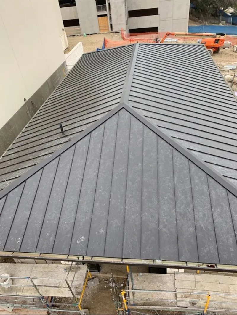 Commercial metal roof construction with crane equipment in Benson